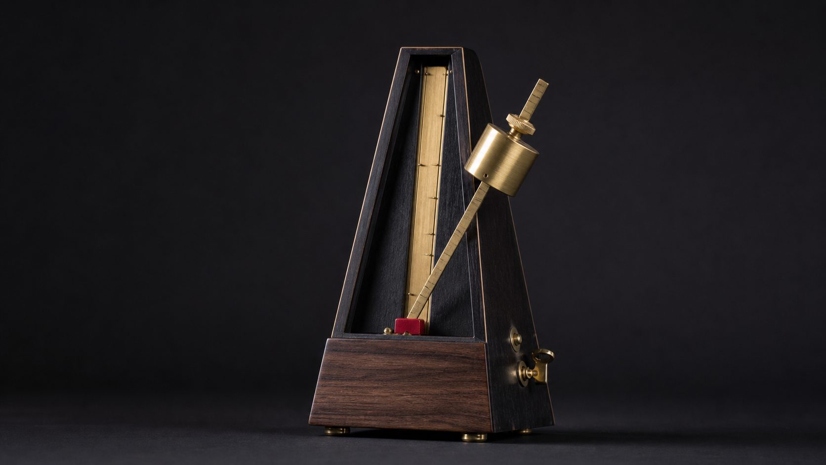 A brass-and-wood metronome mid-swing with a crimson pendulum weight.