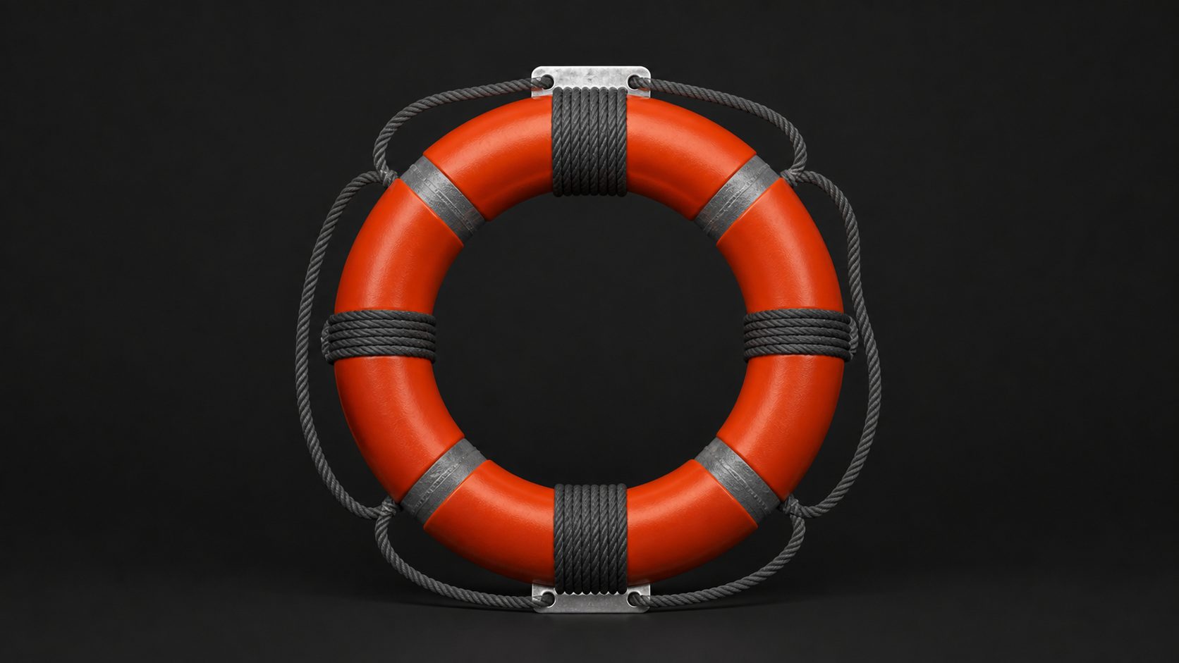 A ring life preserver banded in orange on a dark studio background.